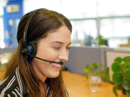 Giganet Full Fibre Broadband Customer Service Support member smiling while chatting to custom on the phone