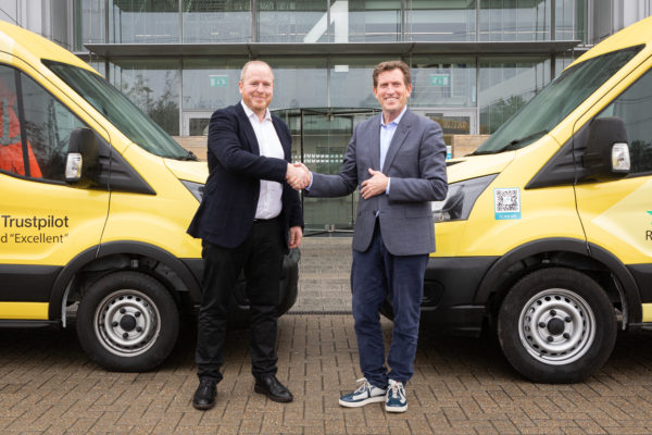 CityFibre & Giganet CEO's shaking hands in front of yellow Giganet full fibre branded vans