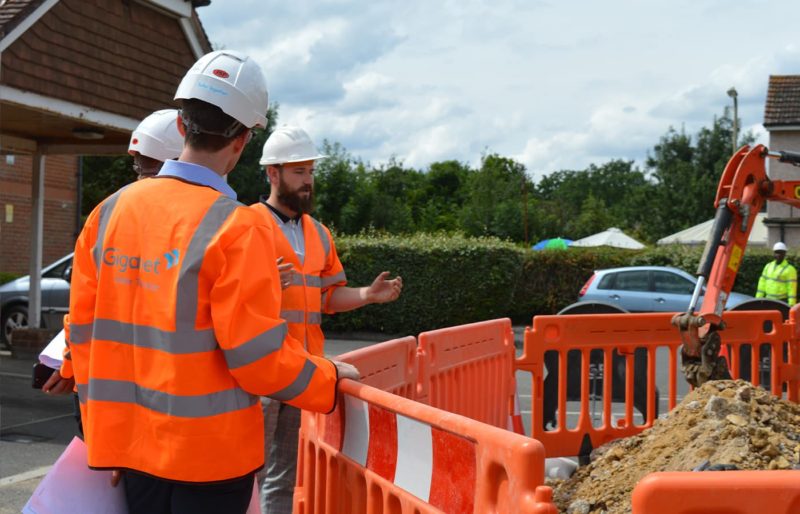 Giganet engineers wearing orange high visibility jackets installing fibre optic cables in the ground for full fibre broadband services